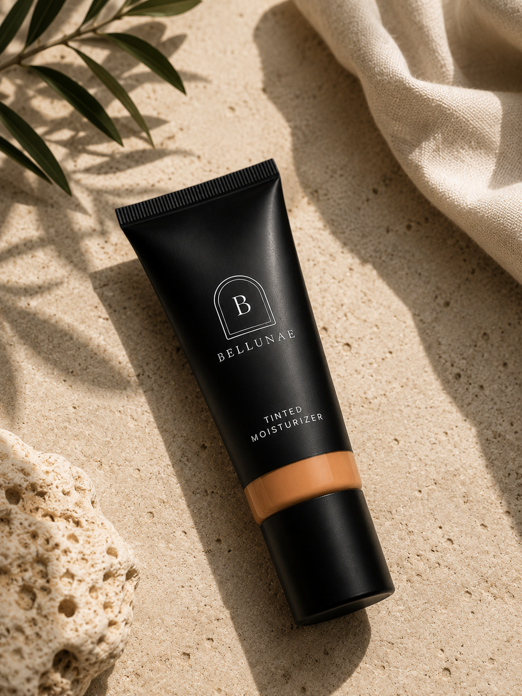 Bellunae Tinted Moisturizer on sand with palm shadow